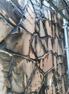 高圧洗浄で汚れが落ちていく薬石外壁の洗浄風景 新潟市