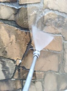 新潟市のお菓子屋 薬石外壁を専用薬剤で洗浄中の様子