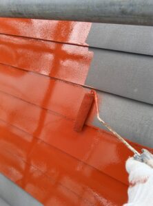 ローラーで屋根にサビ止めを塗布している様子（新潟市 お菓子屋さん）